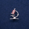 Broche Microscopio con esmalte y strass, 24×31 mm, metal plateado